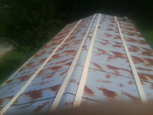 Rusted metal roof panels with new wood purlins before replacement — Storm Damage Roof Repair in Bostwick by Roofing Brothers
